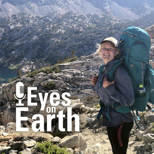 A female scientist stands on the right of the image with a large backpacking backpack, in the background is a view of a rocky area with sparse vegetation and part of a lake is seen to the left. On screen text: Eyes on Earth
