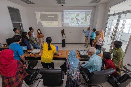 Students in a classroom looking at a projection of data on the wall.